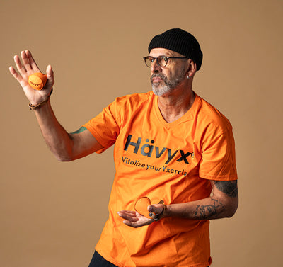 Mann im orangen T-Shirt posiert mit Hävyx Trainingstool