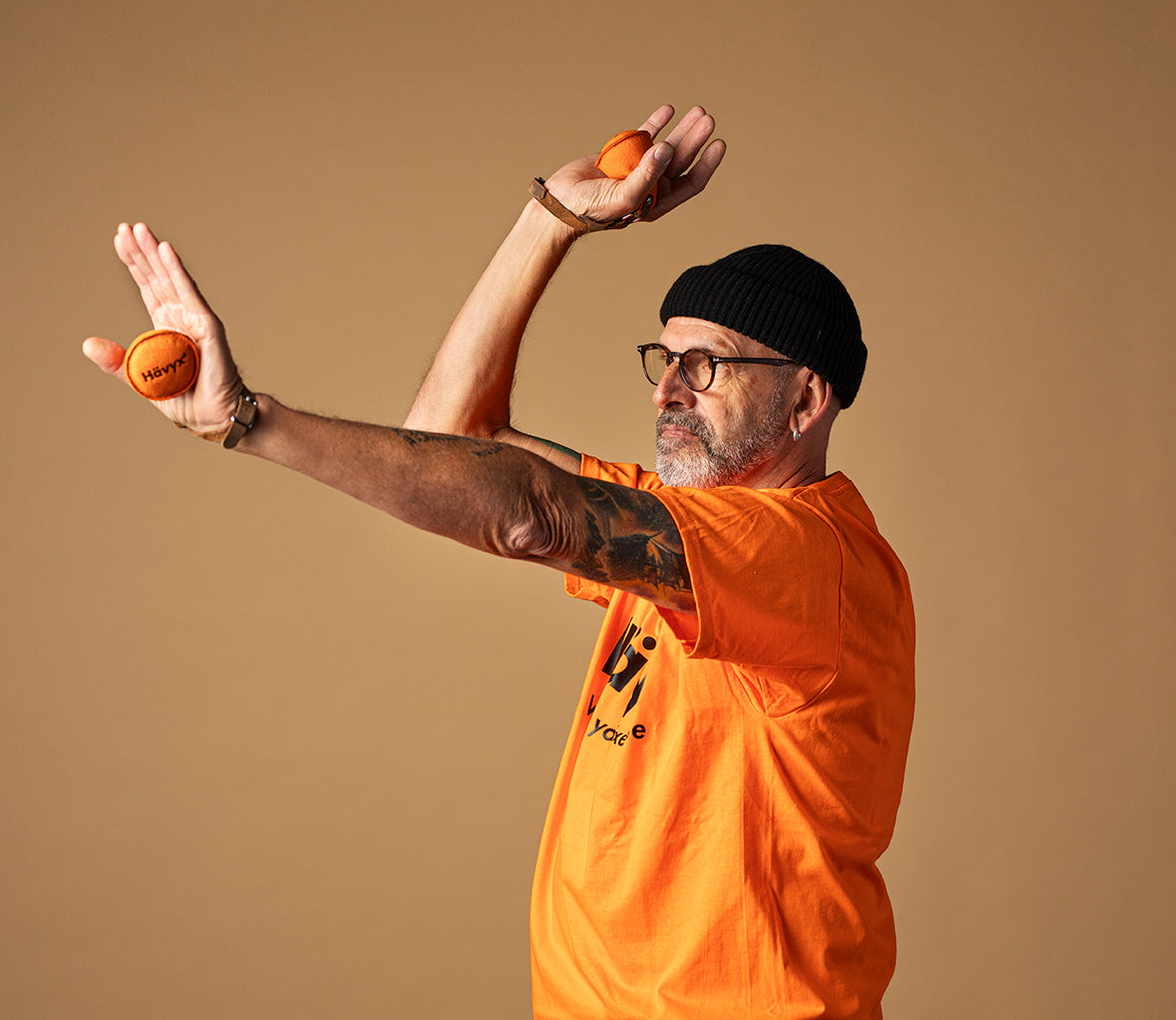 Achim in orangem Shirt mit gestreckten Armen – Hävyx Yxercise