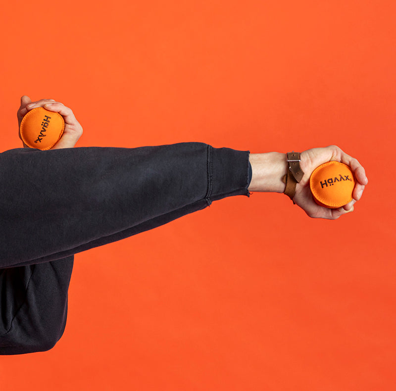 Arme gestreckt mit orangem Hävyx – Bewegungsübung